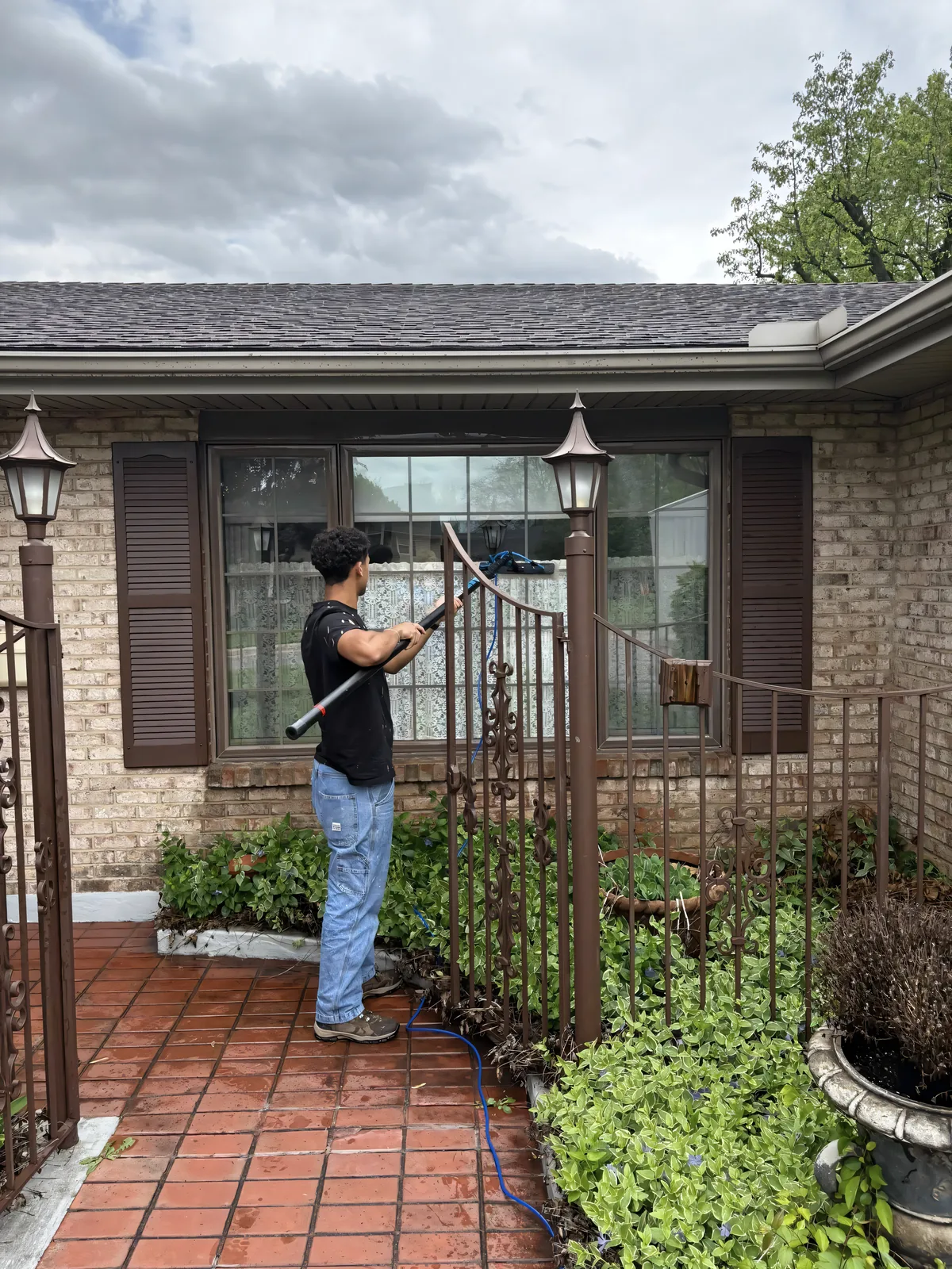 Stoltz tech soft-washing around the windows of a brick home